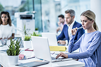 4 people in an office, with color laser machine in the background