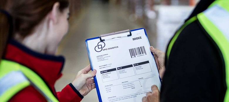 Mężczyzna i kobieta pracujący w magazynie i trzymający fakturę 